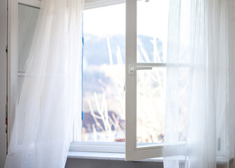 weit geöffnetes Fenster zum Einbringen frischer Luft in das Zimmer - Konzept zum richtigen Heizen und Lüften
