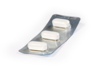 Blister pack of white pills close-up in selective focus