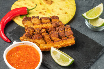 Appetizing pieces of fried brisket with crispy skin, close-up. Mexican style appetizer.