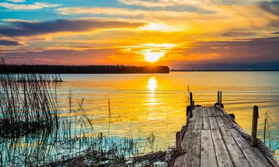 Foto op Plexiglas oranje landschap bij zonsondergang in de zee © kesipun