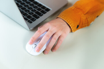 Close-up woman searching and clicking mouse using laptop, online shopping concept. Blurred...