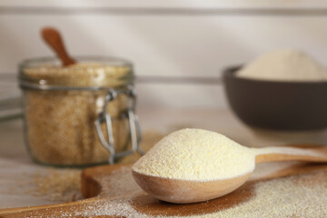 Wooden spoon with quinoa flour on table, closeup