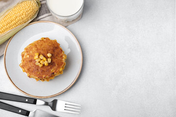 Tasty corn pancakes served on light grey table, flat lay. Space for text