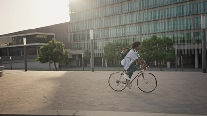 Young African American professional man going to the office by bicycle - Sustainable transport inn the city - Powered by Adobe