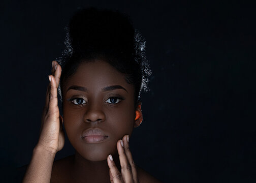 African American black beauty on black background, with attractive healthy smooth skin, shiny, clean and pure. Women beauty and make up, black copy space