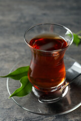Glass with traditional Turkish tea on grey table