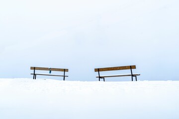 Winter landscape with two old wooden benches in Avoriaz ski resort in Morzine, France - obrazy, fototapety, plakaty