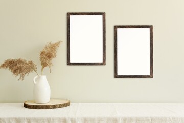 Two dark wood vertical frames hanging on the wall, mockup for design, art, photo presentation,...