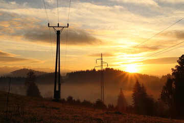 sunrise in the mountains with power lines
