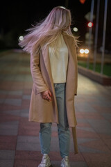 Obraz premium Portrait of a young beautiful fair-haired girl in the night city.