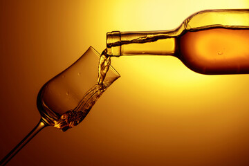 Digestive tulip of premium alcohol on a yellow background.