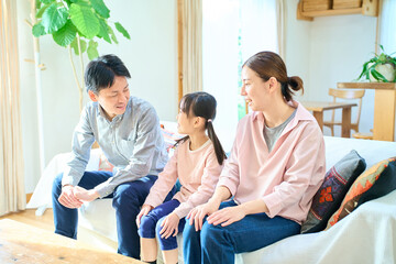 Obraz premium リビングルームで楽しそうに話す親子3人