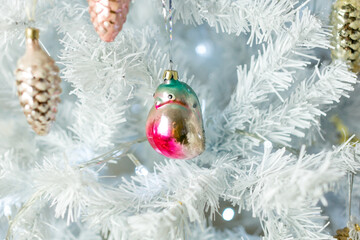 Christmas decoration. Vintage glass bullfinch on a white Christmas tree.