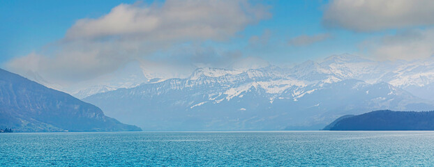 The beautiful view of snow-capped mountain peaks and blue lake of  Swiss Mountain against the blue sky background