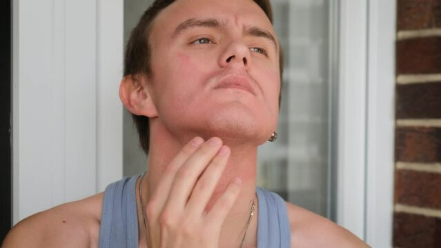 A man with redness on the skin of the neck and face, close-up. Dermatitis