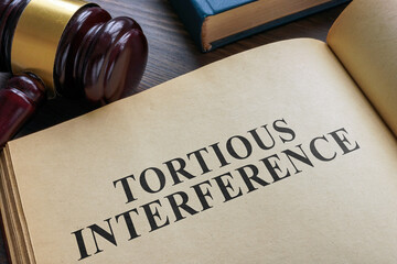 Open book and gavel. Tortious interference concept.