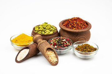 Spices in glass and wooden bowls isolated on a white background.