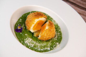 Recipe Breaded soft-boiled eggs and creamed spinach with parmesan. High quality photo