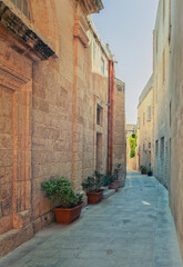 Fototapeta na wymiar Malta Mdina. The narrow street leads along lines of old medieval stone edifices 