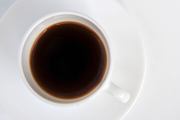 White cup with coffee on white