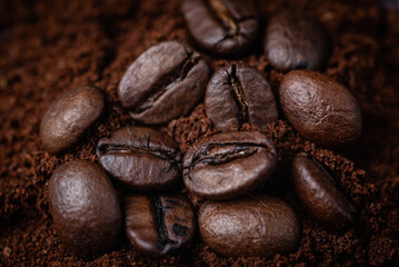 Roasted coffee .Close up. Lying on a bed of ground coffee. Studio macro photography.