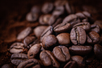 Roasted coffee .Close up. Lying on a bed of ground coffee. Studio macro photography.