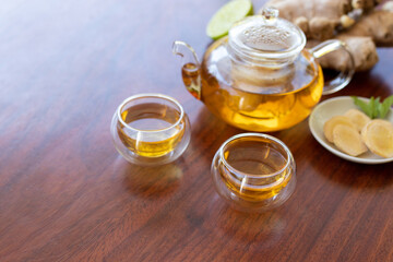 cup of tea with ginger root, lime, cinnamon and teapot on white background. Health drink concept..