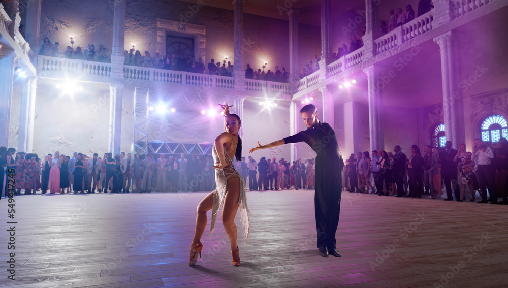 Wall mural couple dancers perform latin dance on large professional stage. ballroom dancing.