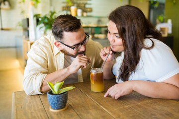 Romantic couple sharing an iced coffee