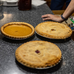 top down view of three pies just before they are sliced up for serving at a family gathering