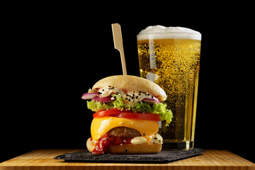 Delicious homemade hamburger and beer on a wooden table, fast food, close-up