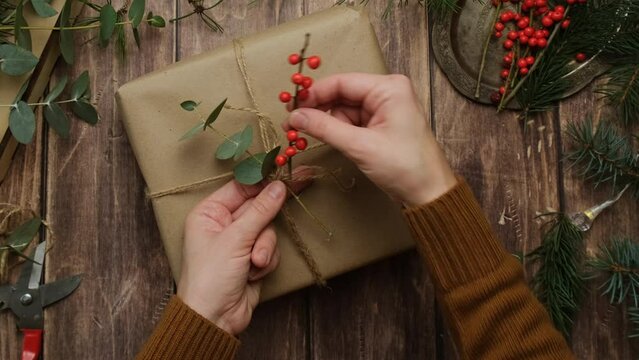 Sustainable Christmas present packaging. Hands wrapping gift box for Christmas.
