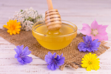 Obraz na płótnie Canvas Honey.Fresh flower honey in a glass bowl and bloom on a white background. 