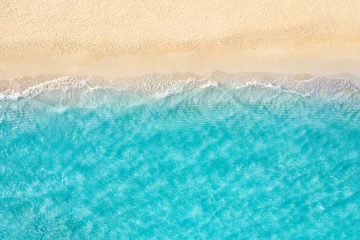 Fototapeten Summer seascape beautiful waves, blue sea water in sunny day. Top view from drone. Sea aerial view, amazing tropical nature background. Beautiful bright sea waves splashing and beach sand sunset light © icemanphotos
