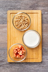 Bowls with ingredients for a healthy breakfast on a wooden table, close-up