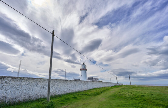 Loop Head lighthouse at the west coast of Ireland on a storma day with dramatic clouds, County Clare, Republic of Ireland