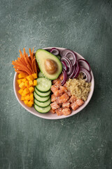 Poke bowl with quinoa and salmon and raw vegetables, healthy food bowl, top view