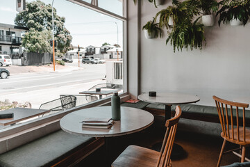 Interior of a bright cafe with wooden tables and chairs without people ,George cafe, New Zealand