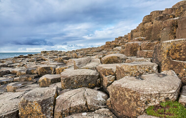 Irish coastline with Volcanic hexagonal basalt columns of Giant`s Causeway at sunset in Northern...