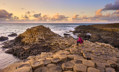 Irish coastline with Volcanic hexagonal basalt columns of Giant`s Causeway at sunset in Northern...