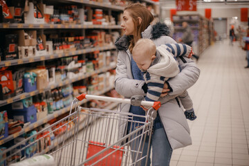 Shopping with kids. Mother and child buying in supermarket. Mom and her little son are in a grocery store shopping for food