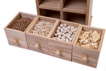 Pattern of raw cereals, beans and seeds, top view texture, mix of groats in square wooden box. Small wooden box with cells with beans lentils oatmeal seeds isolated on white background,