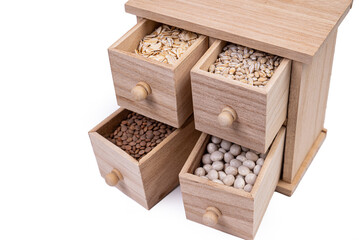 Pattern of raw cereals, beans and seeds, top view texture, mix of groats in square wooden box. Small wooden box with cells with beans lentils oatmeal seeds isolated on white background,