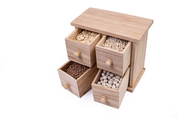 Pattern of raw cereals, beans and seeds, top view texture, mix of groats in square wooden box. Small wooden box with cells with beans lentils oatmeal seeds isolated on white background,