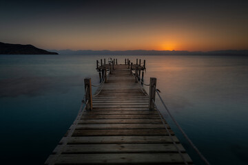 Fototapeta na wymiar Wooden pier and sunrise over the beautiful Akaba Bay Egypt