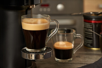 Close-up glass cup with prepared natural coffee from a coffee machine.