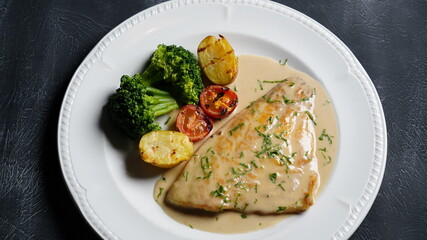 fish dish with sauce on black background