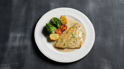 fish dish with sauce on black background