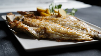 grilled fish dish with sauce on black background