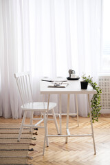  comfortable home office working space at home, white room with table and chair, cozy desktop office from home, remote working place with plant and rug, copy space, freelancer blog